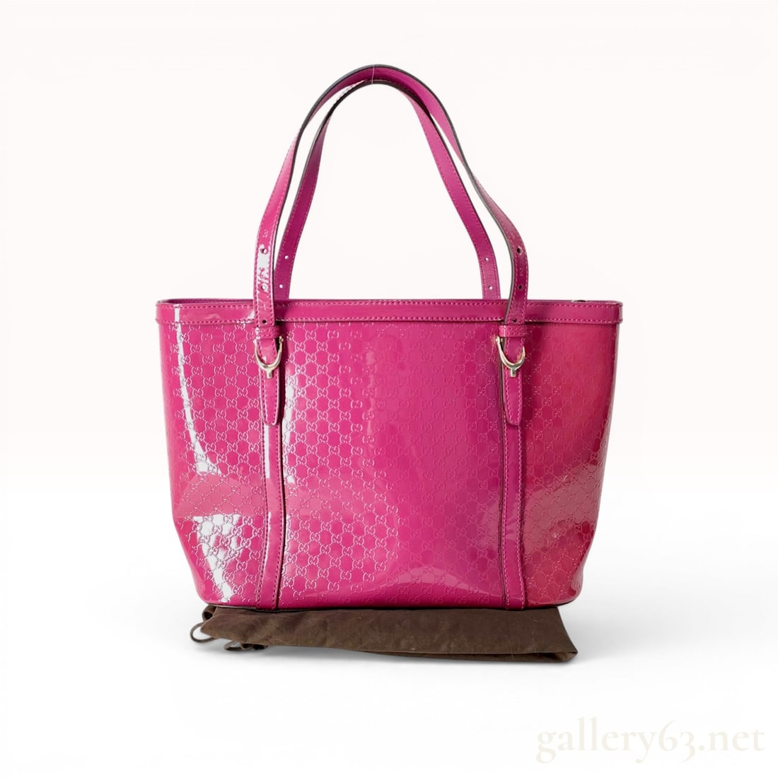Gucci Microguccissima Patent Leather Nice Tote Bag: A Gucci tote bag from the Nice collection, crafted from fuchsia pink patent leather featuring an all-over embossed Microguccissima interlocking GG pattern. The bag is designed with two adjustable flat
