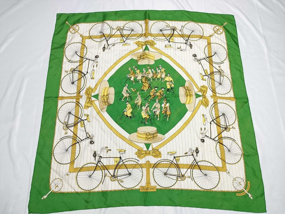 Hermes Les Becanes Silk Scarf: Hermes silk twill scarf in the Les Becanes (The Bicycles) pattern designed by Henri d'Origny, originally issued in 1973. The design features a central green diamond-shaped medallion with cyclists, sur
