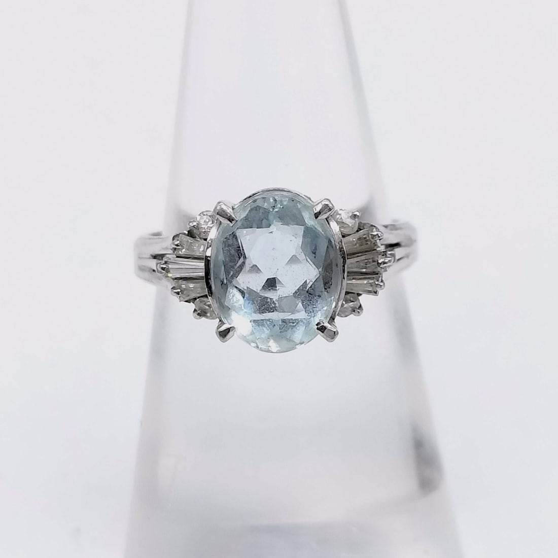 Platinum Aquamarine and Diamond Cocktail Ring: Platinum cocktail ring featuring an oval-cut aquamarine center stone, mid-to-late 20th century. The mounting includes tiered shoulders set with round brilliant and tapered baguette diamonds and an int