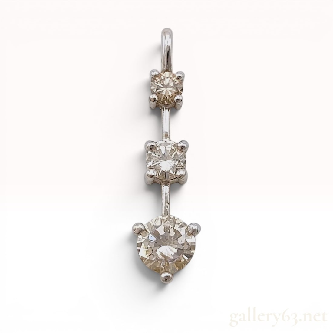 14K White Gold and 1.00ctw Graduated Diamond Three-Stone Pendant: A three-stone graduated drop pendant featuring three round brilliant-cut diamonds set in 14-karat white gold. Each diamond is held in a four-prong basket setting connected by a central metal bar and s