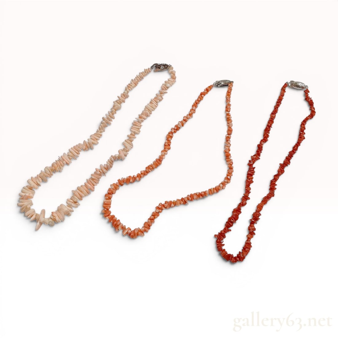 A Trio of Antique Natural Coral Chip and Branch Necklaces with Silver Clasps w/Box: Trio of natural coral necklaces in shades of angel skin pink, orange, and red, mid-to-late 20th century. The collection features graduated branch-style beads and polished chips secured with sterling s
