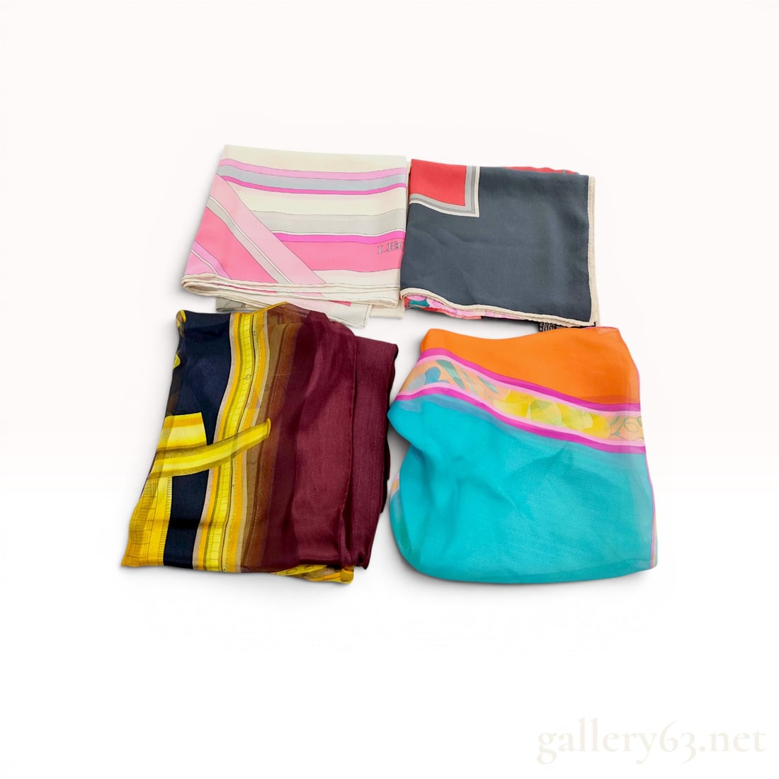 A Collection of Designer Silk Scarves by Leonard Paris: A collection of designer silk scarves from Leonard Paris. These scarves are crafted from 100% silk and feature a variety of vibrant floral and geometric patterns in a palette of pink, turquoise, orang