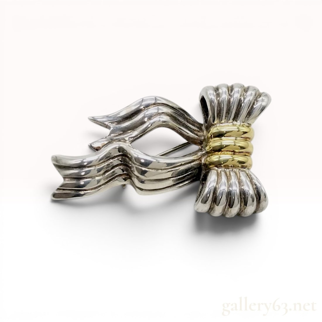 Tiffany & Co. Sterling Silver and 18K Yellow Gold Ribbon Bow Brooch w/Box: Tiffany & Co. ribbon bow brooch featuring a two-tone design. The piece is constructed with polished sterling silver ribbons cinched by a triple-banded 18-karat yellow gold center. It is marked on the 