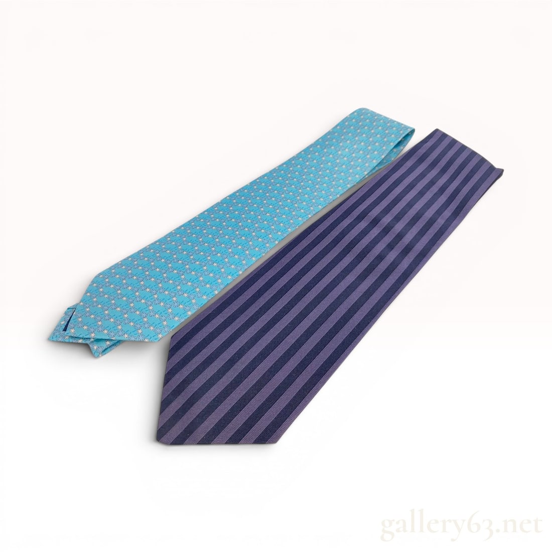 Two Designer Silk Neckties by Salvatore Ferragamo and Etro Milano w/Box: Two 100% silk designer neckties including a light blue Salvatore Ferragamo tie and a striped Etro Milano tie. The Ferragamo tie features a repeating palm tree motif in white and blue and is accompanie