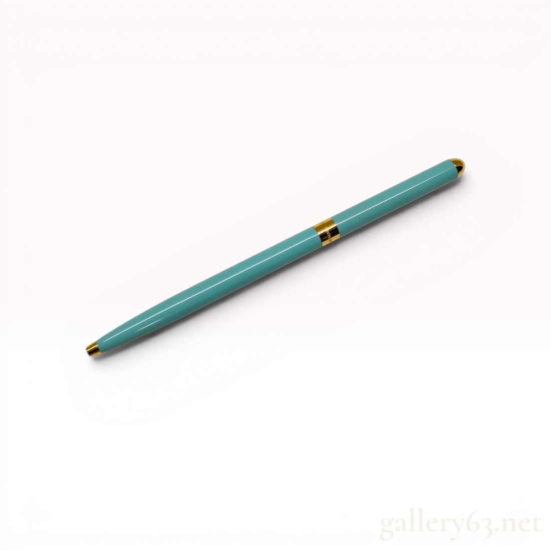 Tiffany & Co. Slim Twist-Action Ballpoint Pen in Tiffany Blue Lacquer and Gold-Toned Trim w/Box: Tiffany & Co. slim twist-action ballpoint pen. The metal barrel is finished in signature Tiffany Blue lacquer with polished gold-toned accents including a conical tip, central band, and rounded fi