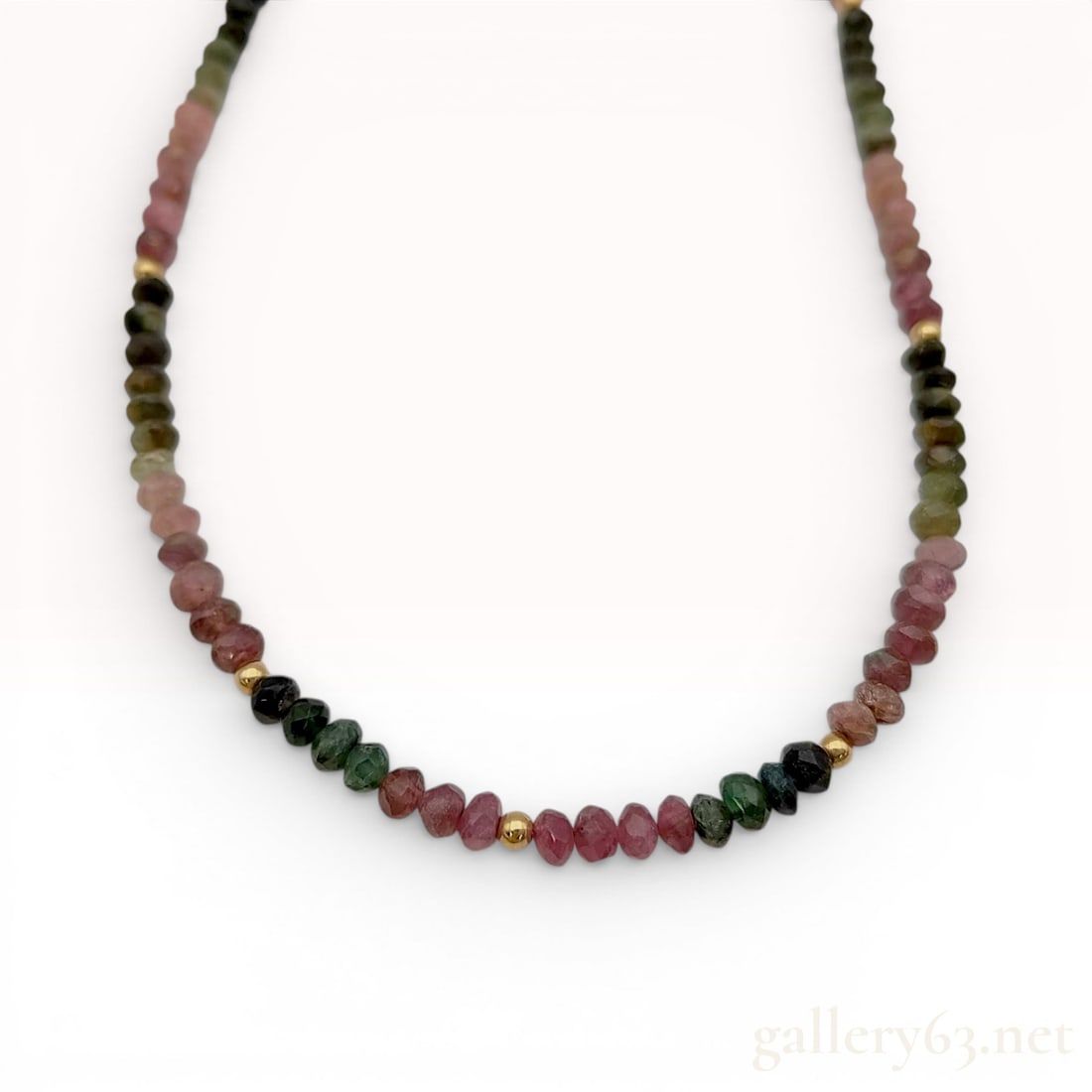 14 Karat Yellow Gold and Multi-Color Tourmaline Faceted Bead Necklace: This beaded necklace is composed of multi-colored tourmaline faceted rondelle beads in shades of pink, olive, green, and dark green. The gemstones are strung on a fine wire and are accented by four sm
