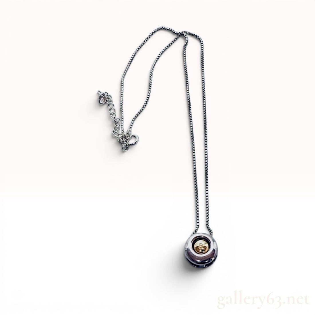 Pinky and Dianne Two-Tone Silver and 10K Yellow Gold Pendant Necklace w/Box: Pinky and Dianne pendant necklace featuring a contemporary circular two-tone design. The pendant consists of a silver open-frame circular donut with a recessed 10 karat yellow gold central element sus