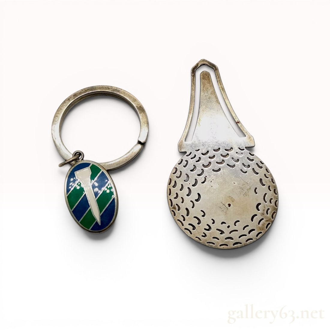 Two Tiffany & Co. Sterling Silver Golf Accessories: Tiffany & Co. sterling silver golf-themed accessories, including a golf ball bookmark and a keyring with an enameled fob. The bookmark is shaped as a dimpled golf ball resting on a tee, and the ke