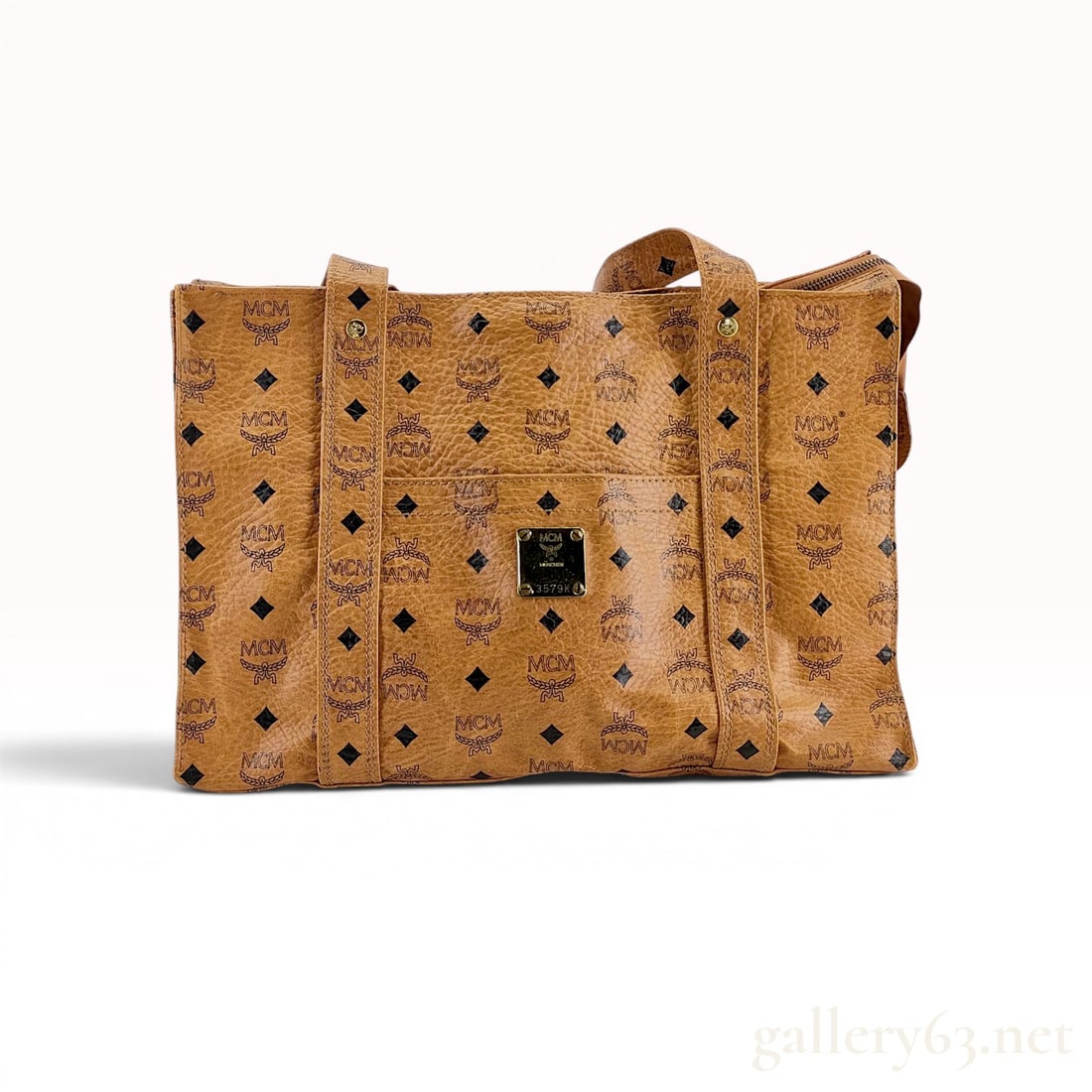 MCM Vintage Visetos Monogram Tote Bag in Cognac: MCM vintage Visetos monogram tote bag in cognac, late 20th century. Constructed from signature Visetos coated canvas with dual flat shoulder straps and a top zipper closure featuring a branded metal p