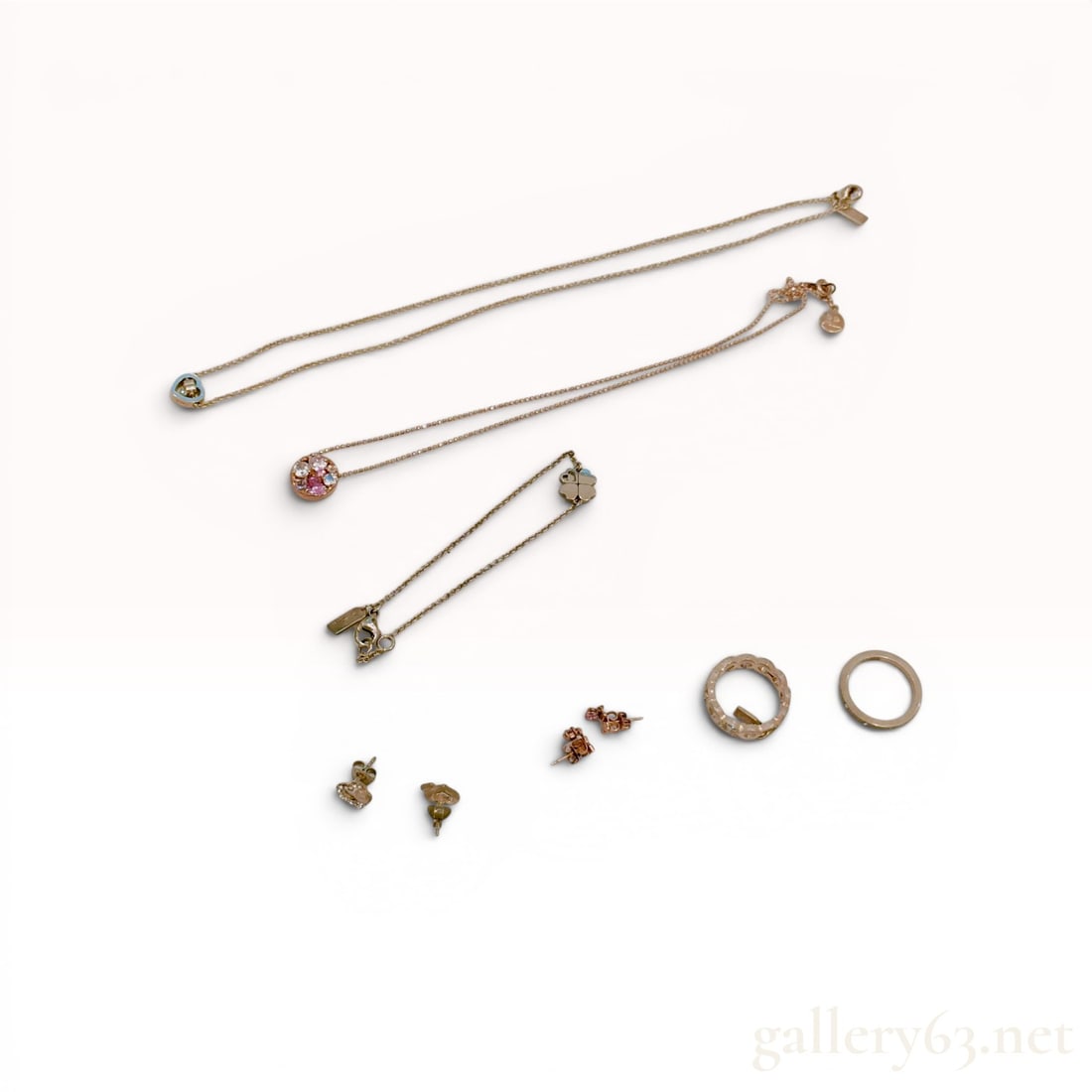 A Collection of Sterling Silver Jewelry Including Coach and Courreges: A collection of designer and fashion jewelry featuring pieces by Coach and Courreges, including necklaces, a bracelet, rings, and earrings. The assortment includes a Coach dual-heart pendant on a cabl