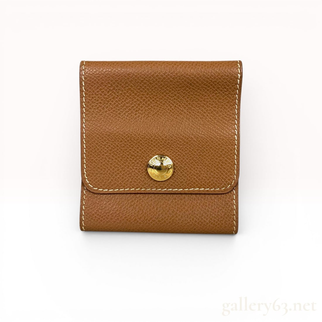 Hermes Gold Epsom Leather Le 24 Coin Purse: A Herm?¨s Le 24 (Vingt-Quatre) coin purse crafted from Gold Epsom calfskin leather, characterized by its rigid, embossed grain. The square-shaped accessory features a fold-over flap and a single inte