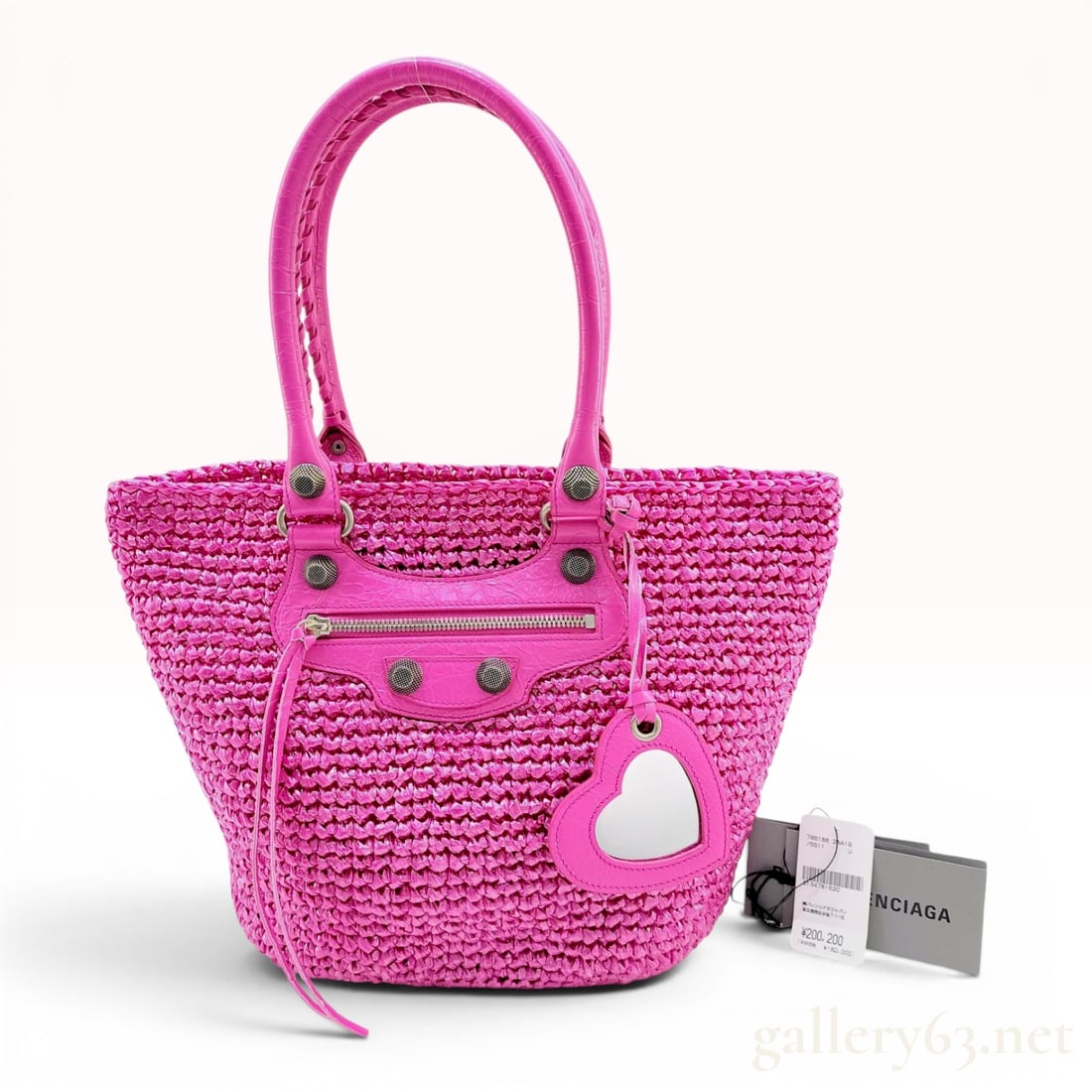 Balenciaga Le Cagole Panier Woven Raffia and Leather Tote Bag: A Balenciaga Le Cagole Panier tote bag crafted from pink woven raffia-style material with tonal pink crinkled Arena leather trim. The basket-style silhouette features a flat oval base and twin top han