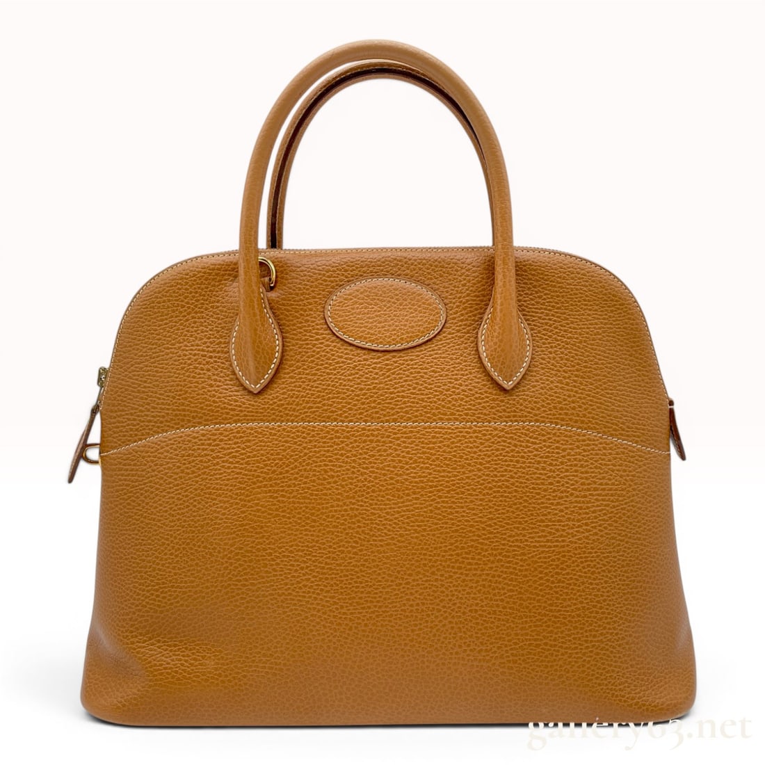 Hermes Gold Clemence Leather Bolide Handbag with Gold-Tone Hardware: A Hermes Bolide handbag crafted from Gold tan Taurillon Clemence leather featuring signature white contrast stitching. This domed satchel design includes two rolled leather top handles and a top zippe