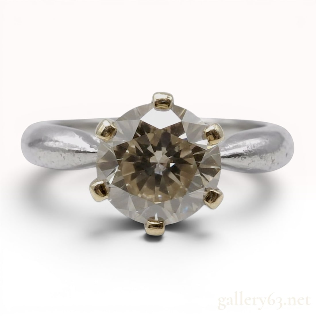 2.078 Carat Brown Diamond Solitaire Ring in Platinum and 18 Karat Yellow Gold: This solitaire ring features a two-tone construction consisting of a yellow gold head and a white metal shank. The center stone is a single round brilliant-cut diamond exhibiting a distinct brownish-c
