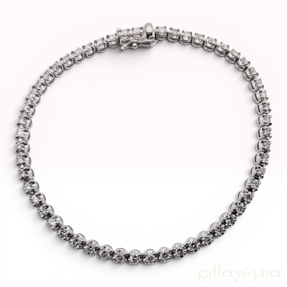 2.00ct Platinum and Diamond Tennis Bracelet: A platinum tennis bracelet featuring a continuous line of articulated links set with round brilliant-cut diamonds. Each diamond is held in a four-prong illusion-style setting. The bracelet is secured 