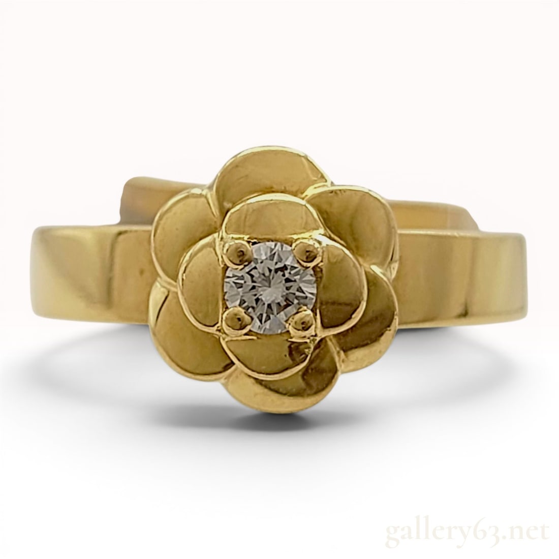 Chanel 18K Yellow Gold and Diamond Camelia Ring: This Chanel ring from the Camelia collection is crafted in 18 karat yellow gold. The design features a tiered camellia floral motif with a single round brilliant-cut diamond set in a four-prong mount 