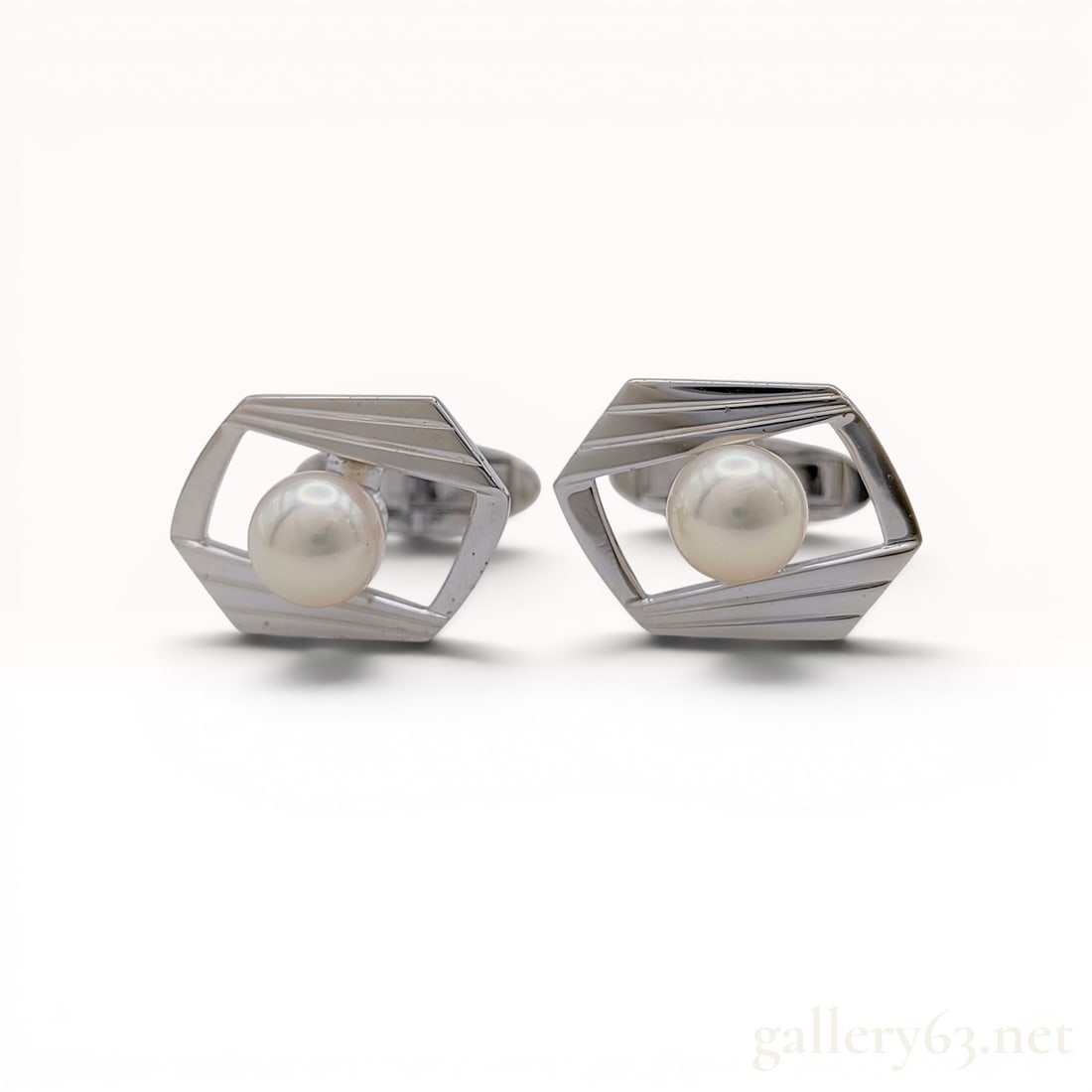 A Pair of Mikimoto Cultured Pearl and Silver Cufflinks with Box & COA: A pair of Mikimoto cultured pearl and silver cufflinks. Each cufflink features a centrally mounted round white cultured pearl set within an open-work hexagonal frame. The silver frame is accented with