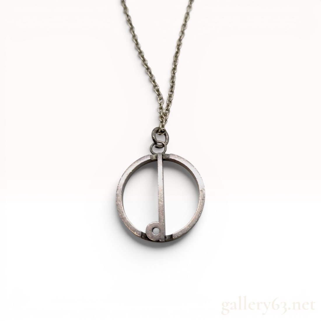 London Hallmarked Dunhill Sterling Silver Modernist Pendant Necklace: Vintage modernist dunhill sterling silver pendant necklace featuring a minimalist circular openwork design. The pendant is suspended from a trace-link chain. The outer rim of the pendant is struck wit