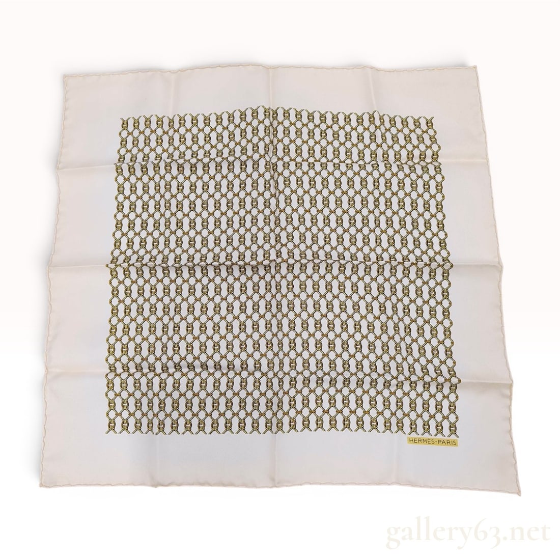 Hermes Silk Gavroche with Nautical Rope Lattice Pattern: This Hermes silk gavroche, or pocket square, features a nautical-themed lattice design. The pattern is comprised of knotted ropes and interlocking gold-tone rings on a cream-colored ground. The item i