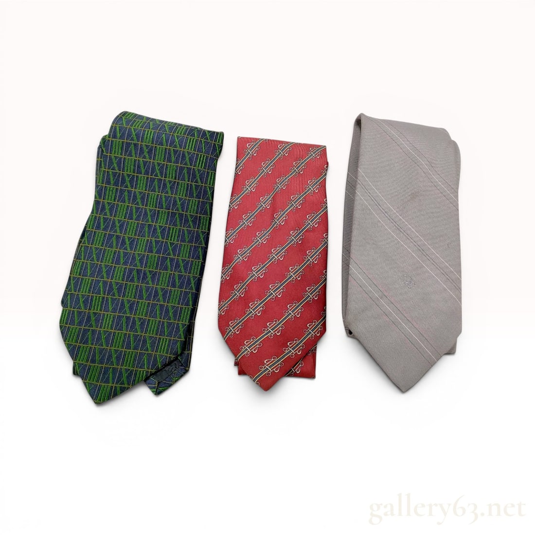 Three Designer Silk Neckties Including Tiffany and Co. and Fendi: This lot comprises three silk neckties from various makers. The first tie is a Tiffany and Co. silk necktie featuring a dark navy blue ground with a repeating pattern of Roman numerals in shades of gr