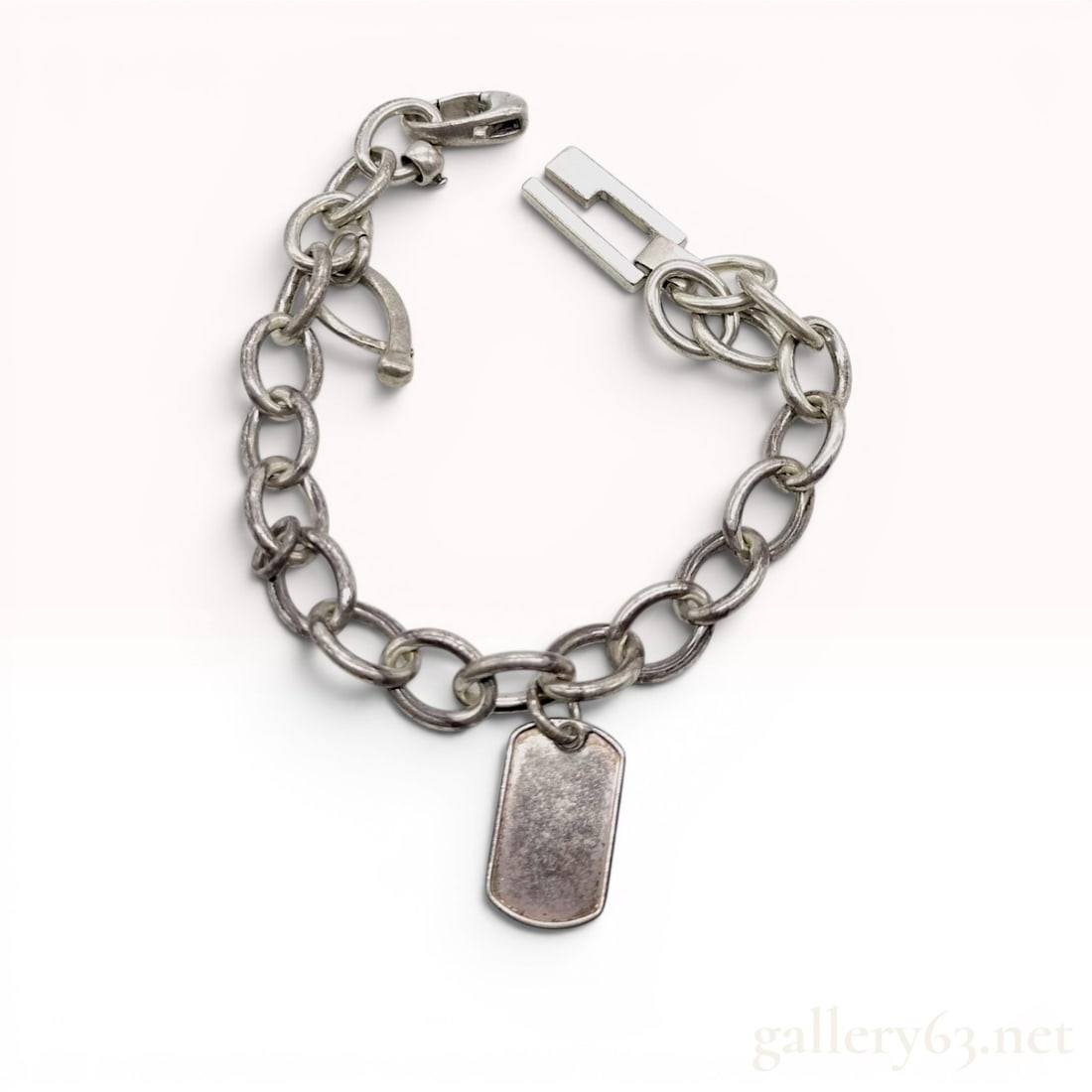 Gucci Sterling Silver Dog Tag Link Bracelet with Presentation Box: Gucci sterling silver chunky link bracelet featuring a suspended rectangular dog tag charm. The jewelry is composed of heavy rolo links and includes a stylized G logo element and a decorative T-bar co