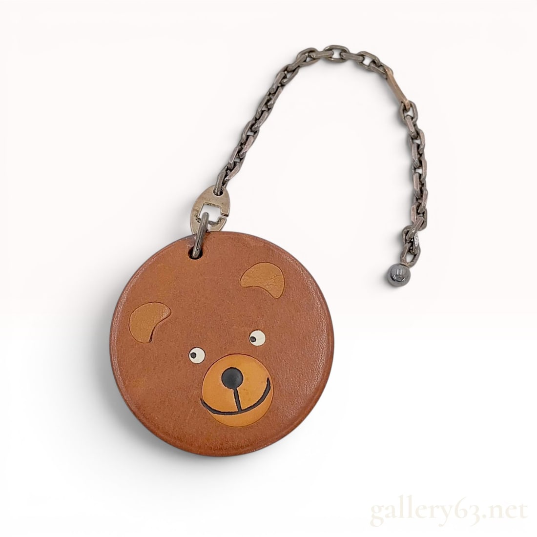 Hermes Leather and Sterling Silver Bear Motif Bag Charm with Box: A bag charm produced by Hermes featuring a stylized bear motif. The circular pendant is crafted from brown leather with tan leather inlays for the ears and snout, and black and white leather details f