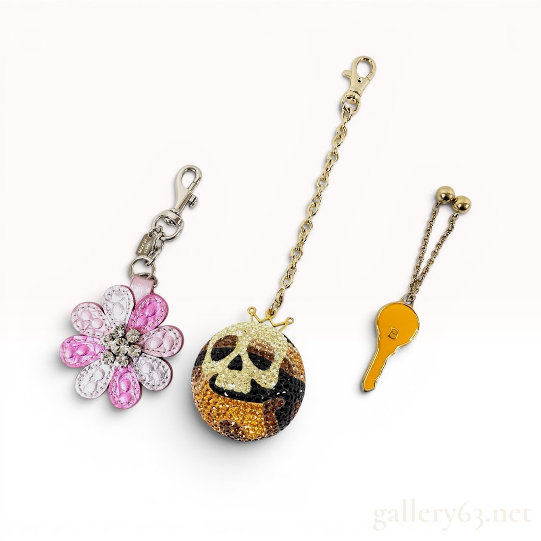 A Trio of Designer Bag Charms and Keychains by Coach, GaGa Milano, and Bally: A collection of three designer bag charms and keychains comprising pieces by Coach, GaGa Milano, and Bally. The Coach flower bag charm is constructed from multiple layers of pink leather petals in var