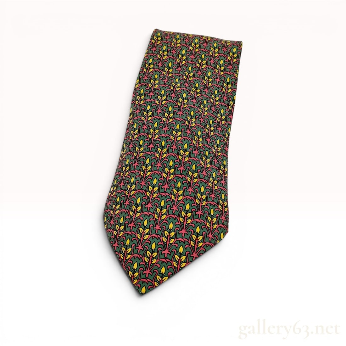 Hermes 7591 SA Silk Botanical Print Necktie: This necktie by Hermes features an allover botanical print composed of a repeating motif of stylized red scrolling vines and yellow leaves or buds set against a forest green ground. The pattern is fur