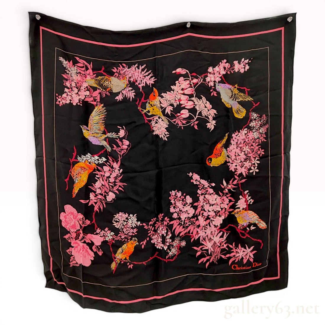 Christian Dior Birds and Blossoms Silk Scarf: A square silk scarf from the designer brand Christian Dior featuring a black field decorated with a central motif of various colorful birds perched on delicate pink flowering branches. The birds, incl