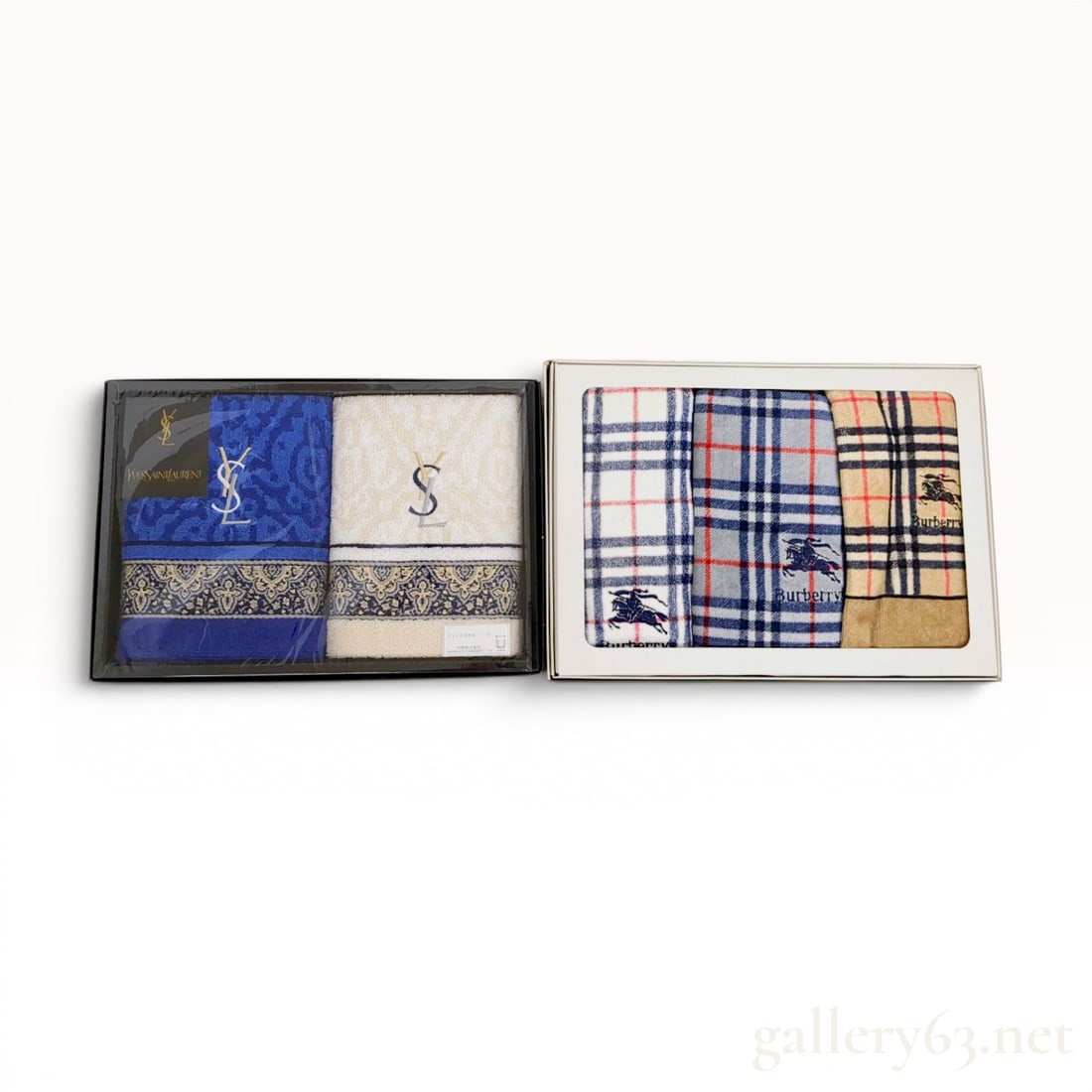 Two NOS Designer Home Gift Sets from Yves Saint Laurent and Burberrys: This lot features two sets of designer face towels, each in its original presentation box. The first set is a two-piece Yves Saint Laurent collection. It consists of one royal blue and one cream-color