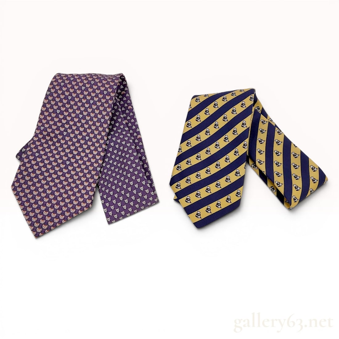 Two Hermes Silk Neckties featuring Cat, Mouse, and Panda Motifs: A lot of two 100 percent silk neckties manufactured by Hermes. The first tie features a repeating grid pattern on a purple ground, alternating between an orange tiger or cat head and a light gray mous