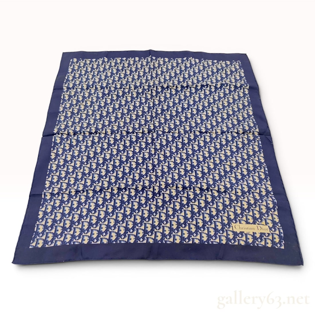 Christian Dior Oblique Monogram Silk Scarf 70cm: Christian Dior silk scarf featuring the signature Oblique monogram pattern. The design displays repeating navy blue logo motifs on a cream ground, surrounded by a wide navy blue border. The item is fi
