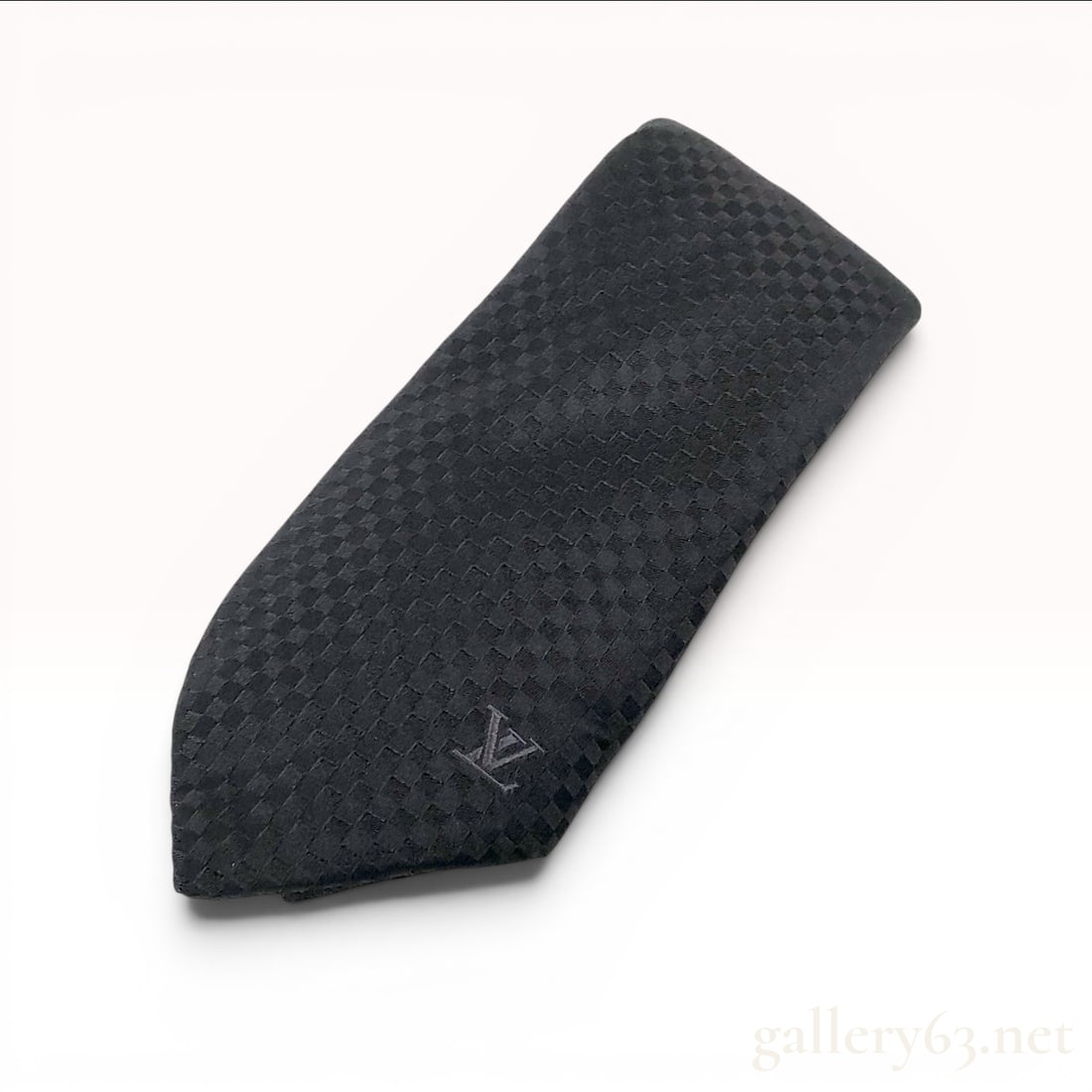 Louis Vuitton Black Damier Silk Necktie: A Louis Vuitton necktie crafted from 100 percent silk featuring a charcoal tone-on-tone Damier checkerboard jacquard weave. The front apron is decorated with a small, tone-on-tone embroidered LV