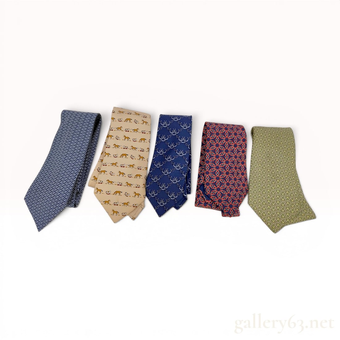 A Lot of Five Hermes Paris Silk Neckties: A lot of five authentic neckties from Hermes Paris crafted from 100 percent silk. This group includes a variety of woven and printed patterns in several colorways. The first tie features a navy blue g
