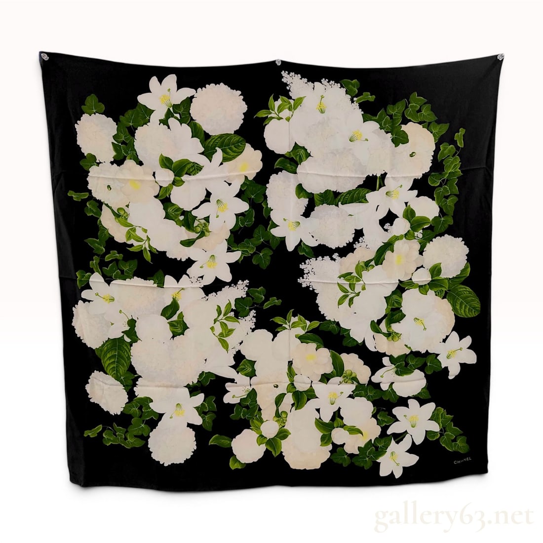 Chanel Silk Floral and Camellia Motif Square Scarf: A square silk scarf by Chanel featuring a black ground with a repeating floral design. The pattern is organized into four quadrants, each containing clusters of white lilies with yellow stamens and wh