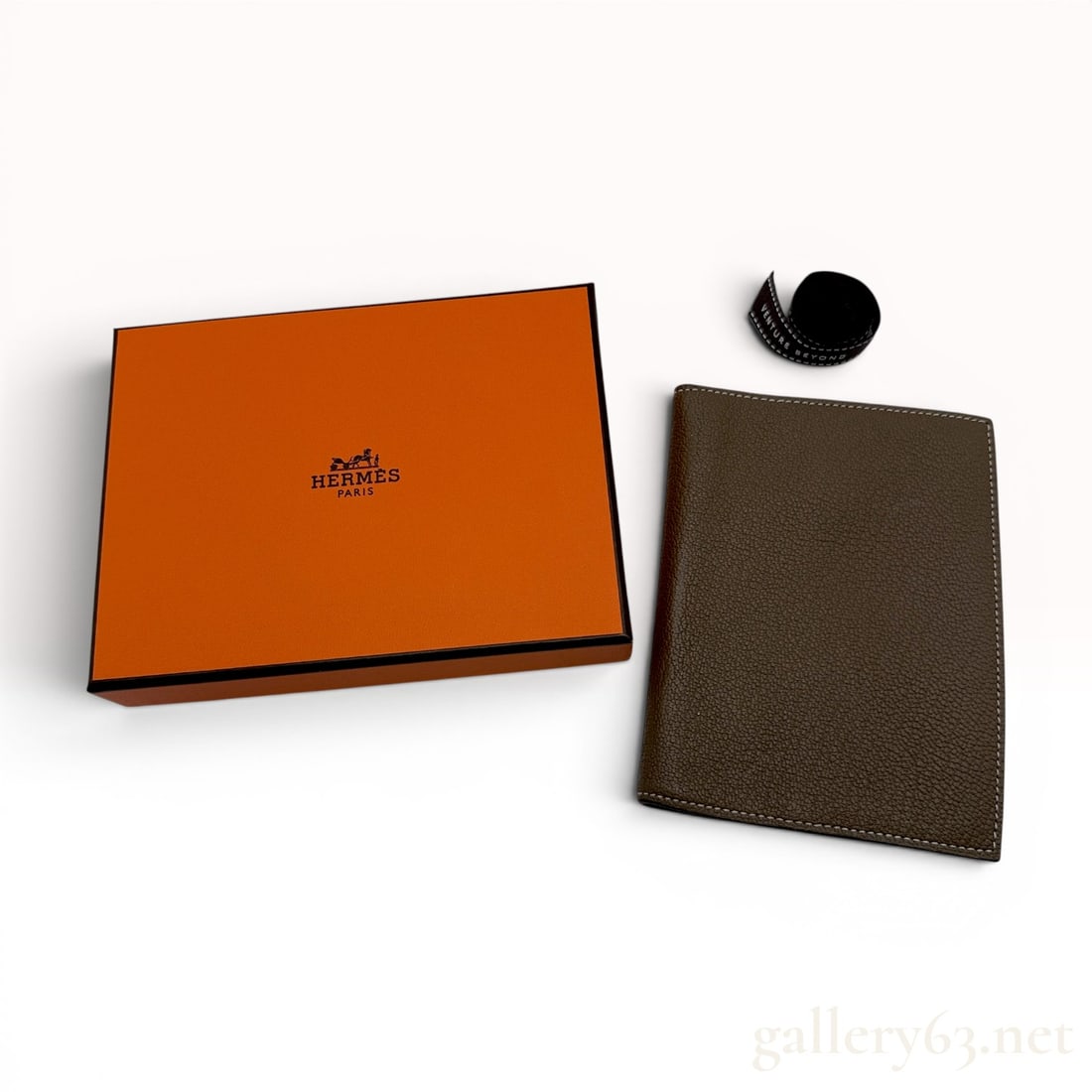 Hermes Grained Leather Passport Holder in Etoupe: This bi-fold passport holder is manufactured by Hermes and crafted from grained calfskin leather in the color Etoupe. The piece features contrasting white perimeter topstitching on both the interior a