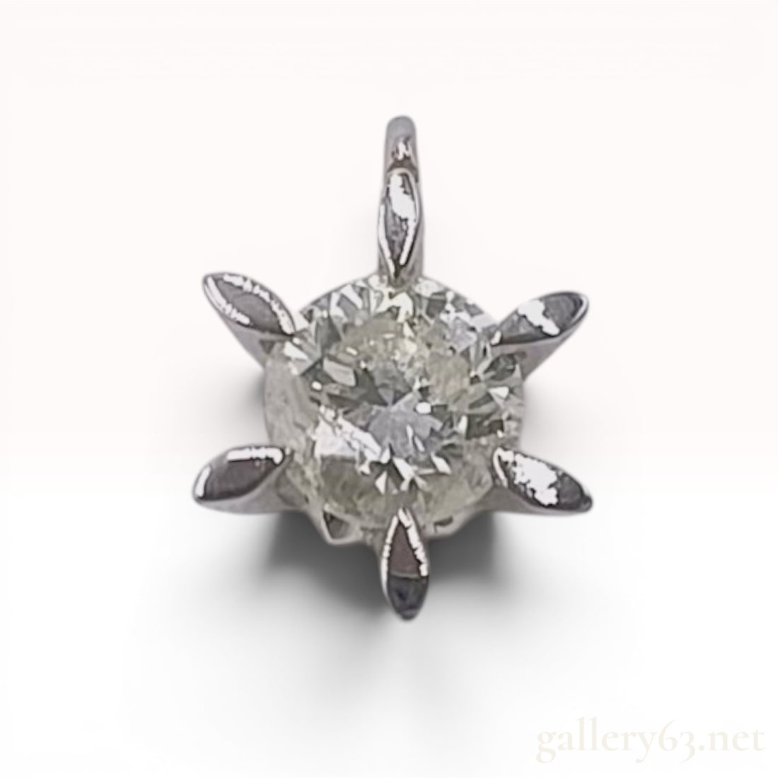 Platinum and 0.33 Carat Diamond Starburst Solitaire Pendant: This is a solitaire diamond pendant crafted in platinum. The piece features a central round brilliant-cut diamond held within a stylized six-prong starburst mounting. The tapered prongs extend outward