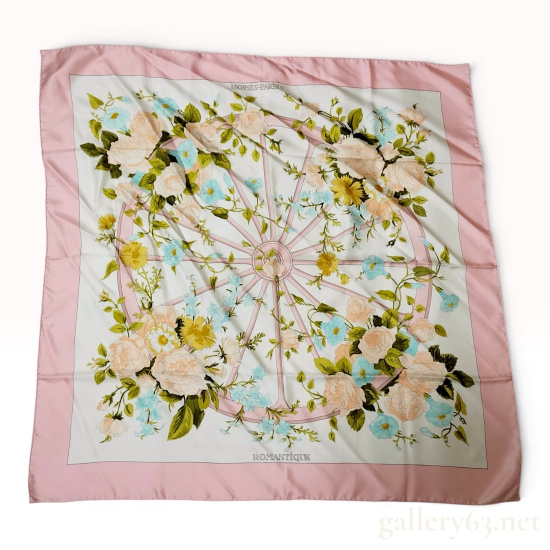 Hermes Romantique Silk Carre 90 Scarf: This Hermes silk twill scarf features the Romantique pattern, which depicts a central pink-spoked wheel motif entwined with various garden flowers including roses in shades of peach and cream, yellow 