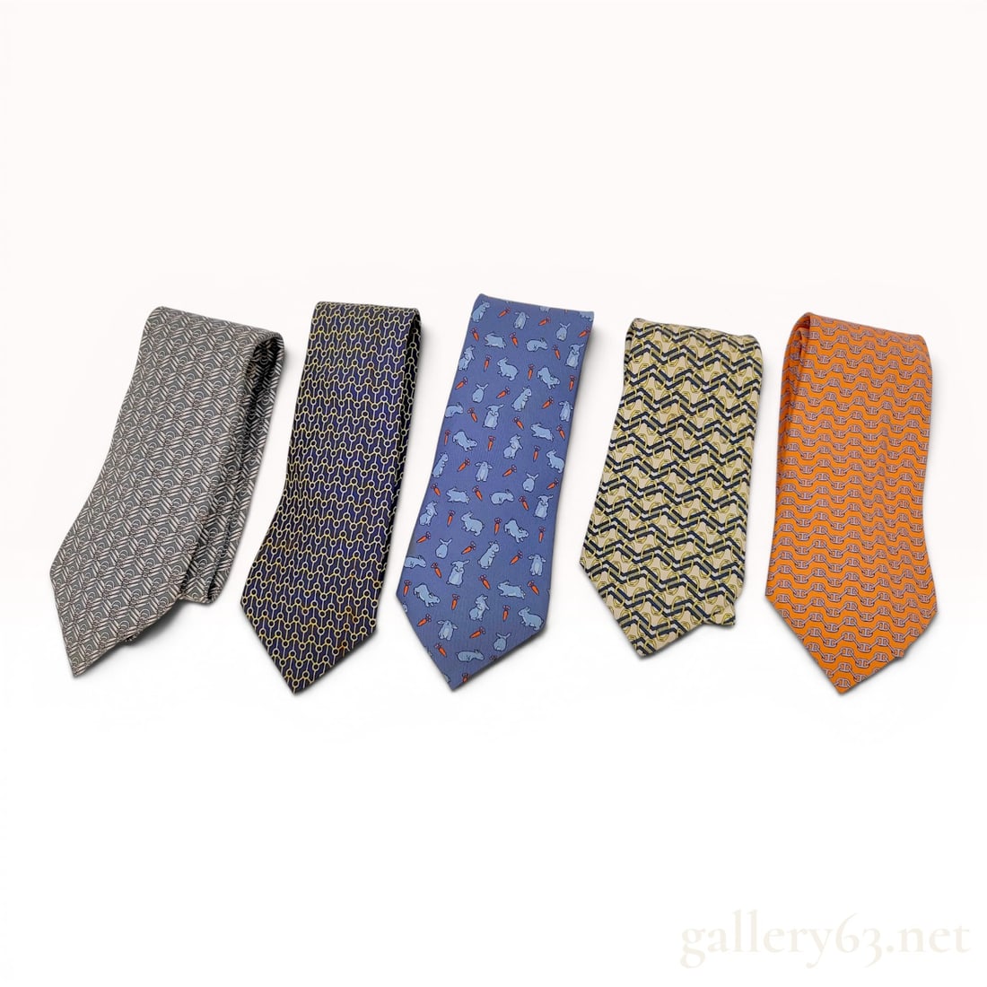 A Collection of Five Hermes Silk Neckties: This collection consists of five men's neckties crafted from 100 percent silk. The assortment features a variety of signature patterns and colors associated with the brand Hermes. The group includes a