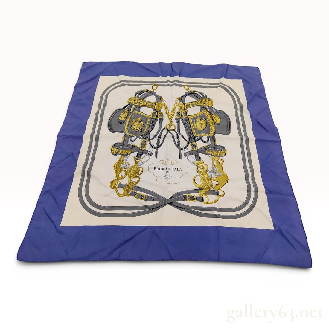 Hermes Brides de Gala Silk Scarf in Royal Blue and Ivory: This Hermes silk twill scarf features the iconic Brides de Gala design by artist Hugo Grygkar. The composition centers on two highly ornate horse bridles with intricate gray and gold-tone equestrian h