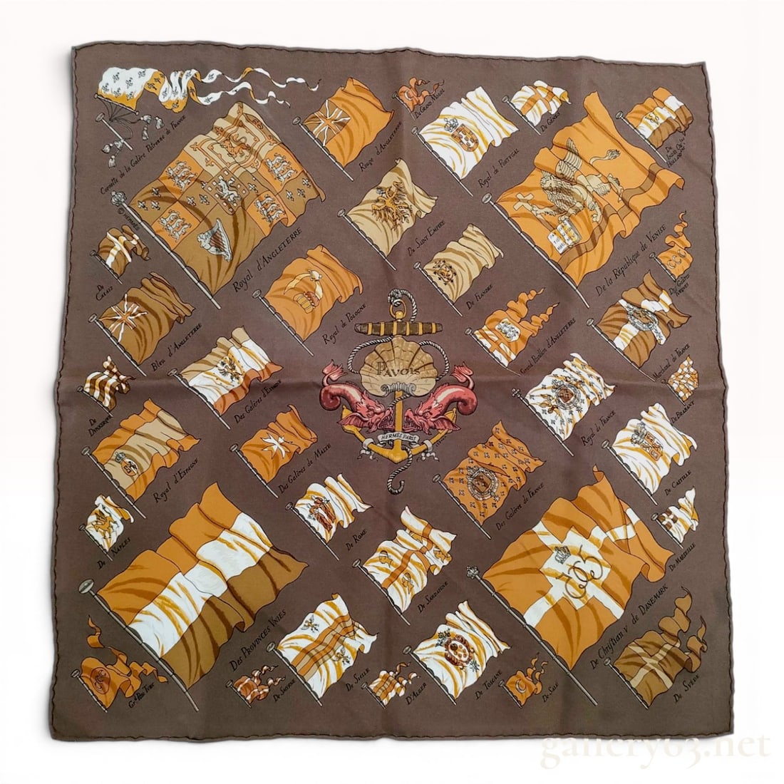 Hermes Pavois Carre 45 Silk Scarf in Brown and Gold with Box: An Hermes silk pocket square, also known as a Gavroche or Carre 45, featuring the Pavois pattern designed by Philippe Ledoux. The design displays a central maritime emblem with an anchor, a scallop sh