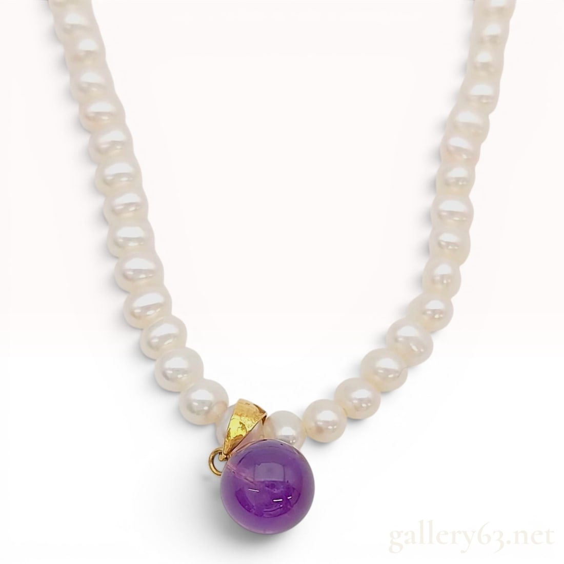 18 Karat Yellow Gold Cultured Pearl and Amethyst Necklace: 18k yellow gold necklace. Single strand of white cultured pearls featuring a spherical gemstone pendant. The pearls are near-round to slightly oval in shape, measuring approximately 3.5 mm to 4 mm in 