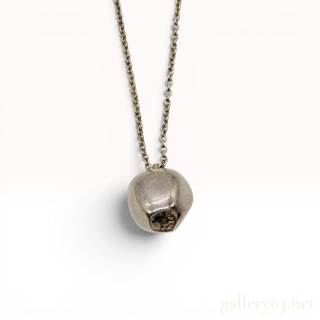 Elsa Peretti for Tiffany and Co Sterling Silver Apple Pendant Necklace: This sterling silver pendant necklace is from the Elsa Peretti collection for Tiffany and Co. The necklace features a three-dimensional apple pendant suspended from a fine cable link chain. The pendan