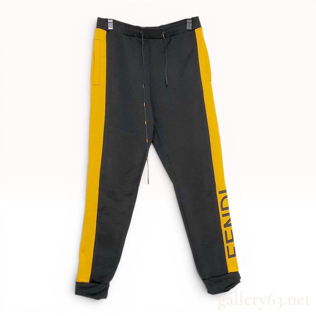 Fendi Roma Men's Black and Yellow Side Stripe Joggers Size 50: These Fendi Roma technical cotton-blend joggers feature a tapered silhouette with an elasticated drawstring waistband. The design is characterized by broad yellow stripes running down the outer side o