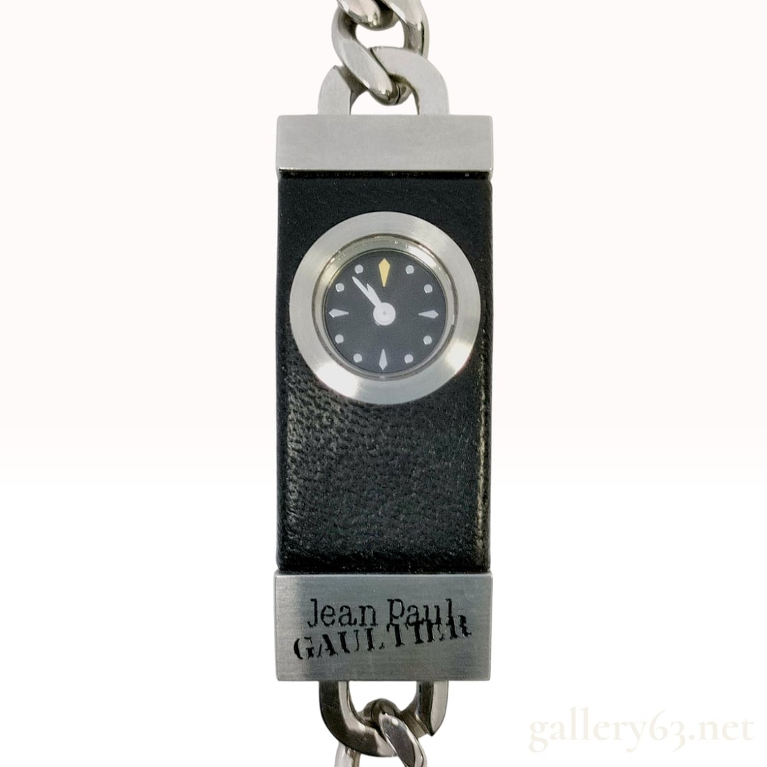 Jean Paul Gaultier Stainless Steel and Black Leather Bracelet Watch: A designer bracelet watch by Jean Paul Gaultier. The watch features a rectangular stainless steel head wrapped in black textured leather, centering a small circular black dial. The dial is equipped wi