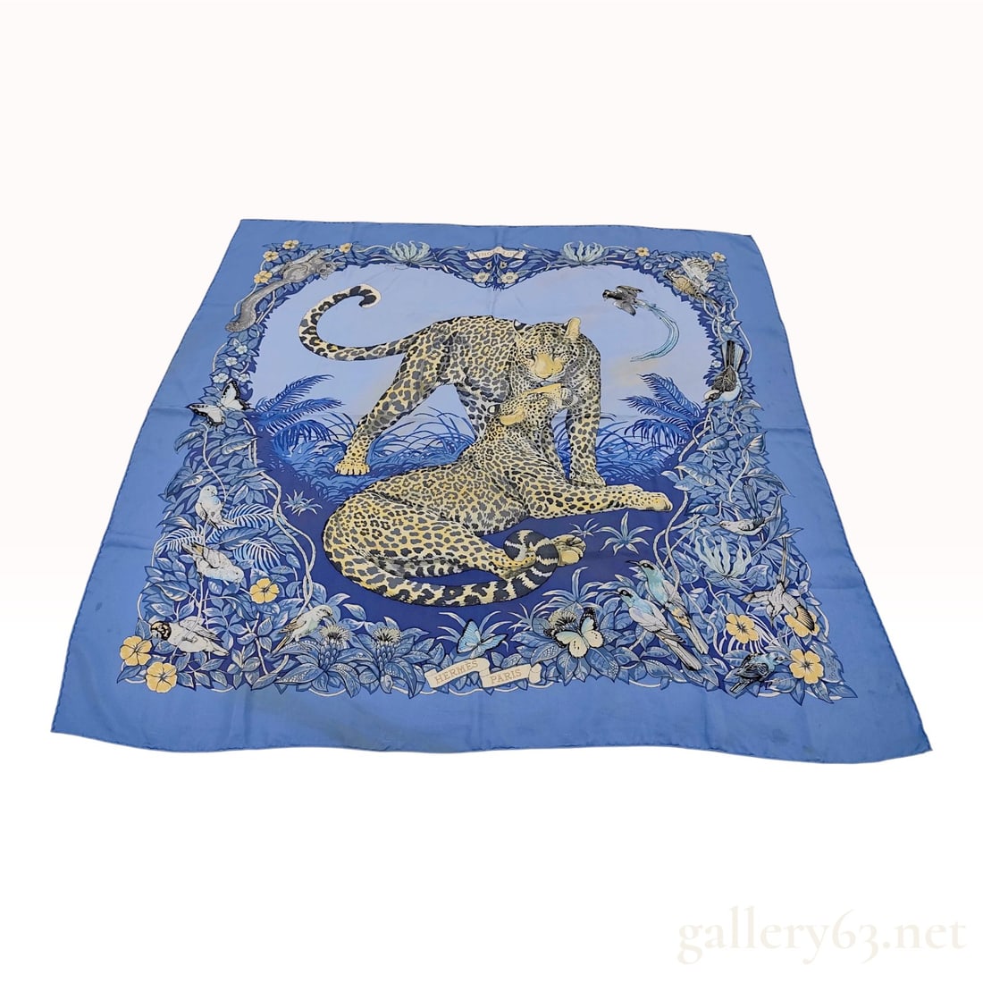 Hermes Jungle Love Silk Twill Carre 90 Scarf: This Hermes silk twill Carre 90 scarf features the Jungle Love pattern designed by naturalist artist Robert Dallet. The central design depicts a pair of leopards in an affectionate pose, surrounded by
