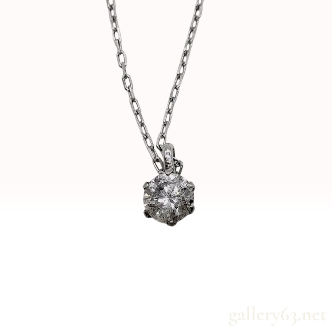 18 Karat White Gold and 0.20 Carat Diamond Solitaire Pendant Necklace: A diamond solitaire pendant necklace featuring a round brilliant-cut diamond. The gemstone is held in an 18 karat white gold six-prong basket setting with an open back. The pendant is suspended by a f
