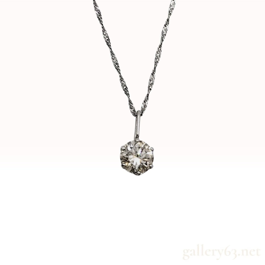 Platinum 0.50 Carat Diamond Solitaire Pendant Necklace: A diamond solitaire pendant necklace featuring one round brilliant cut diamond. The diamond is mounted in a six-prong open-back solitaire setting. The pendant is suspended from a fine, twisted Singapo