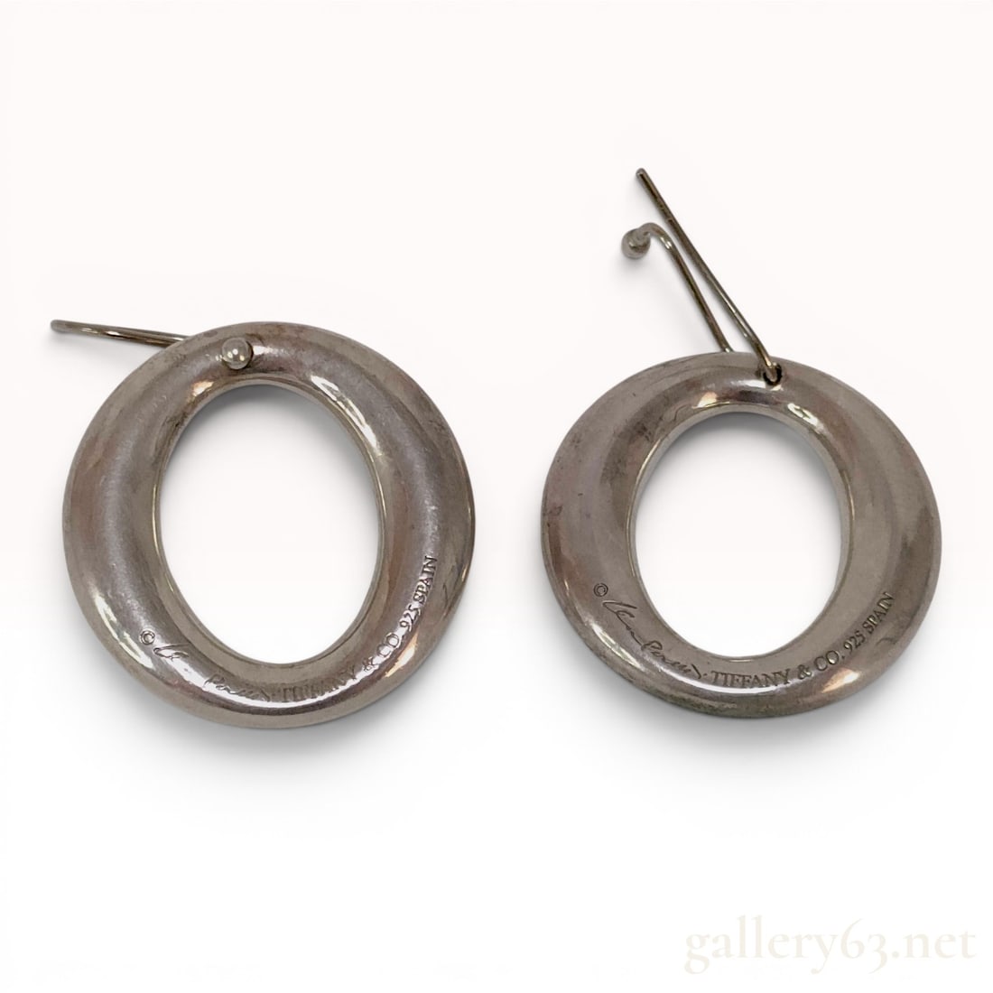 A Pair of Elsa Peretti for Tiffany & Co. Sterling Silver Sevillana Hook Earrings: A pair of matched sterling silver oval open-hoop drop earrings from the Sevillana collection by Elsa Peretti for Tiffany & Co. The earrings feature a polished, hollow-form oval hoop design suspend