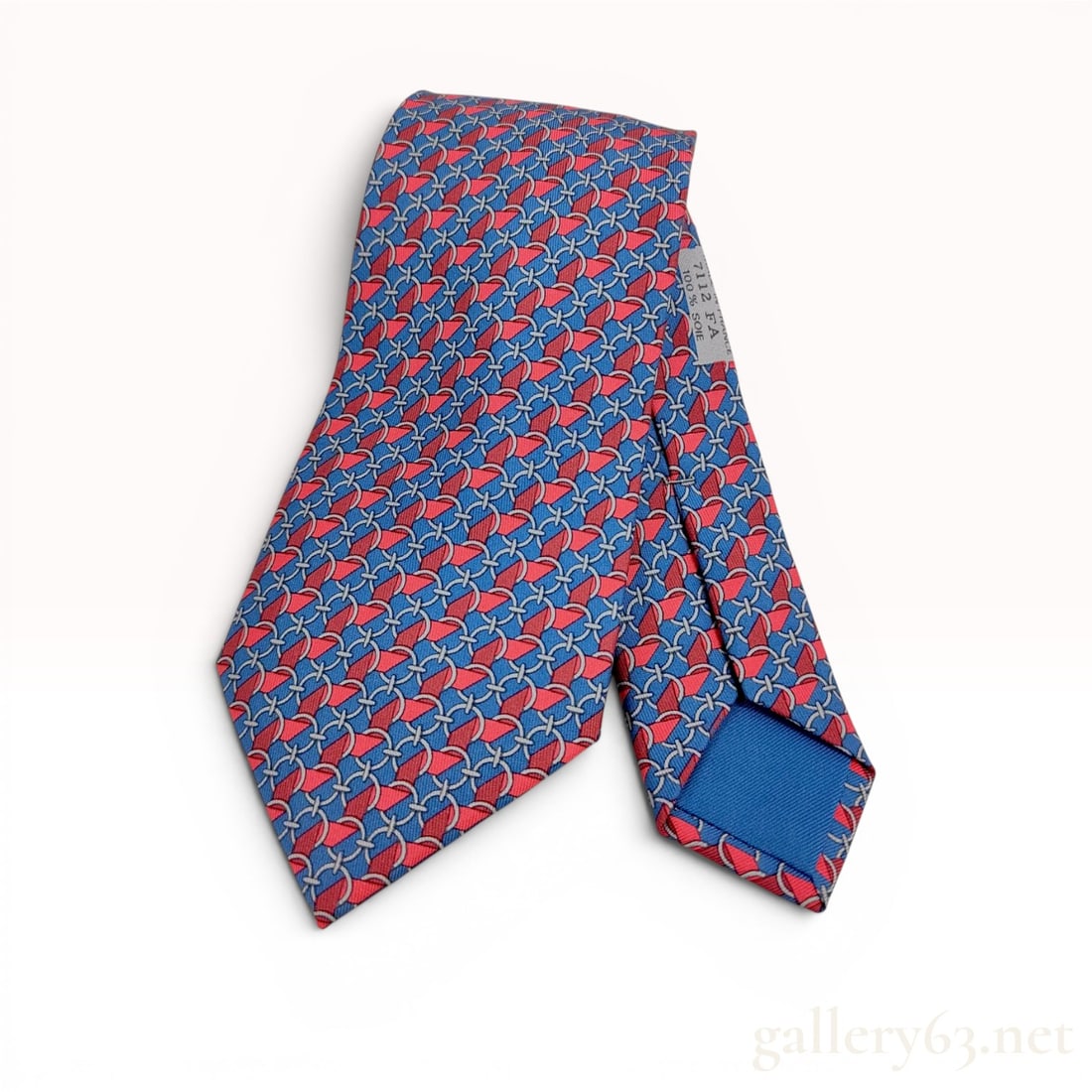 Hermes Paris Silk Necktie Pattern 7112 FA: This necktie is produced by Hermes Paris and was manufactured in France. It is crafted from 100 percent silk and features an intricate repeating pattern consisting of interlocking silver-toned circula